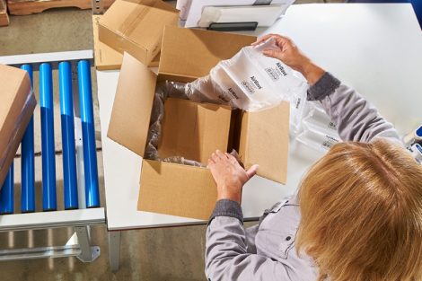 Persoana care ambaleaza cu ajutorul unui sistem de ambalare cu perne de aer